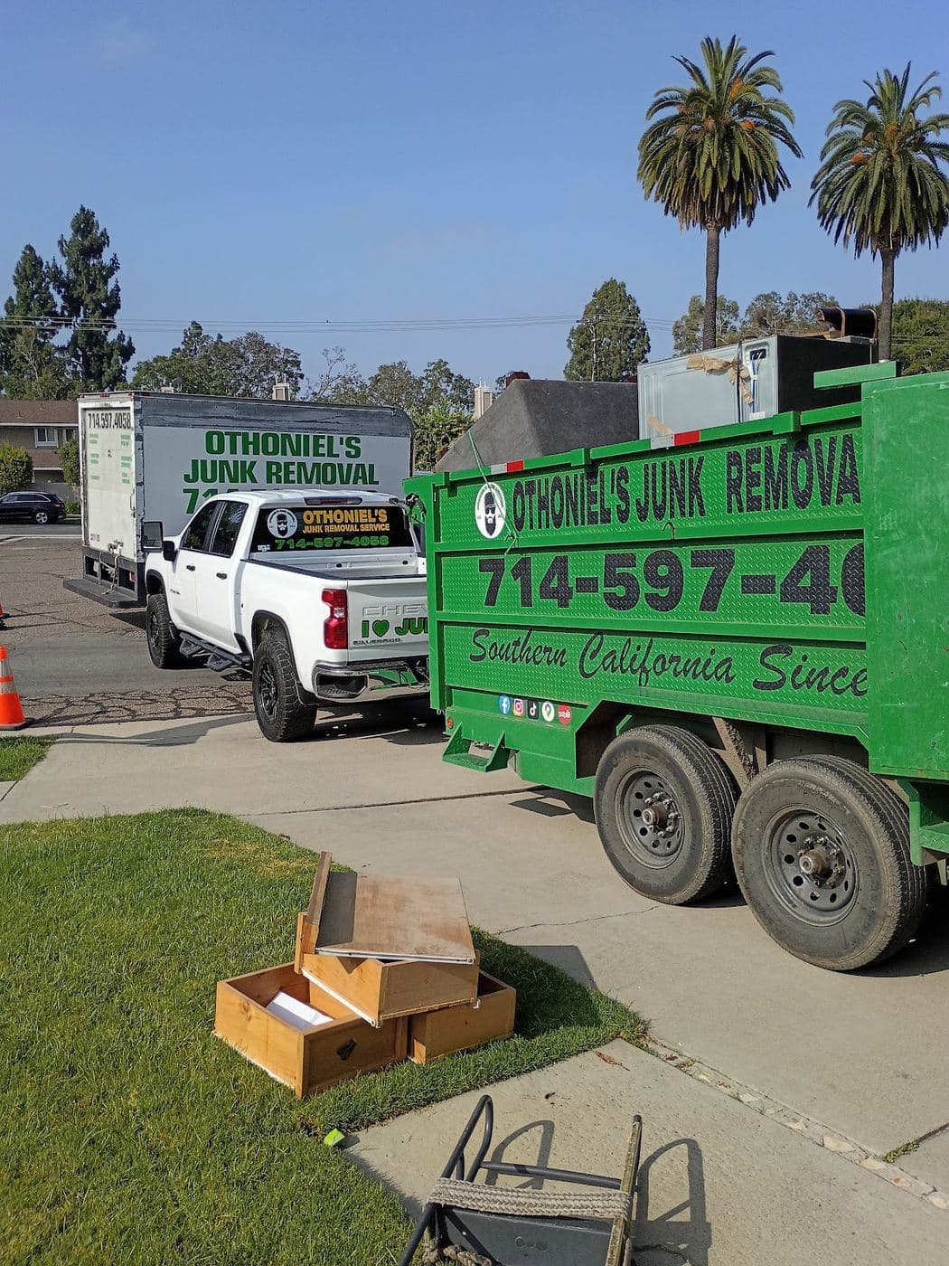 Othoniel's Junk Removal truck and trailer parked on a job site