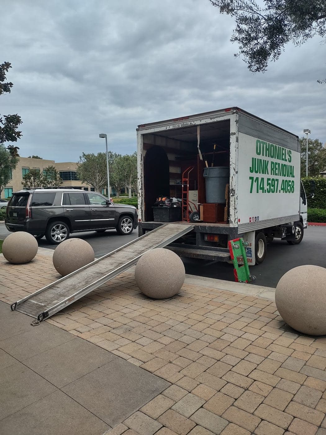 Othoniel's Junk Removal truck with loading ramp deployed and packed with furniture